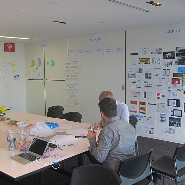 Design team reviewing BMW concepts at a workshop table with reference boards behind